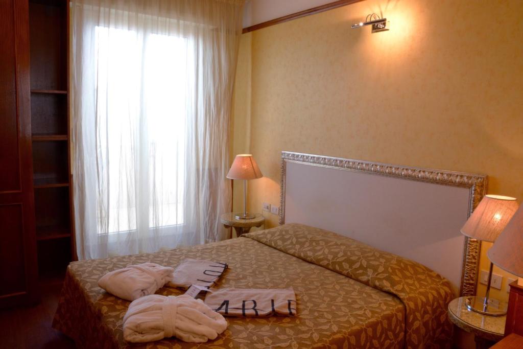a hotel room with a bed with towels on it at AmbientHotels Panoramic in Rimini