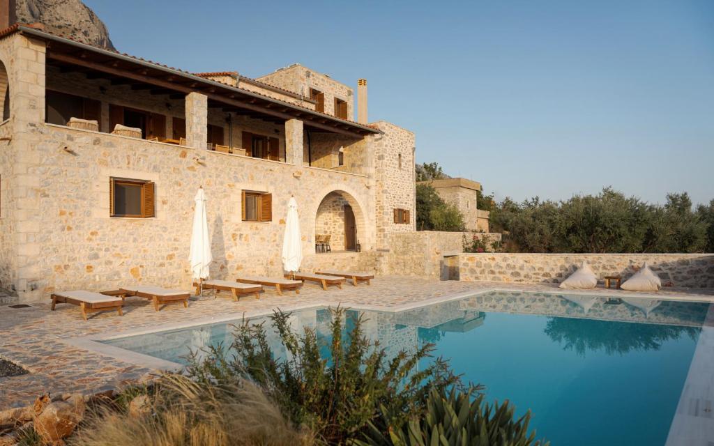 a house with a swimming pool next to a building at Pirgos Petropoulea in Poliána