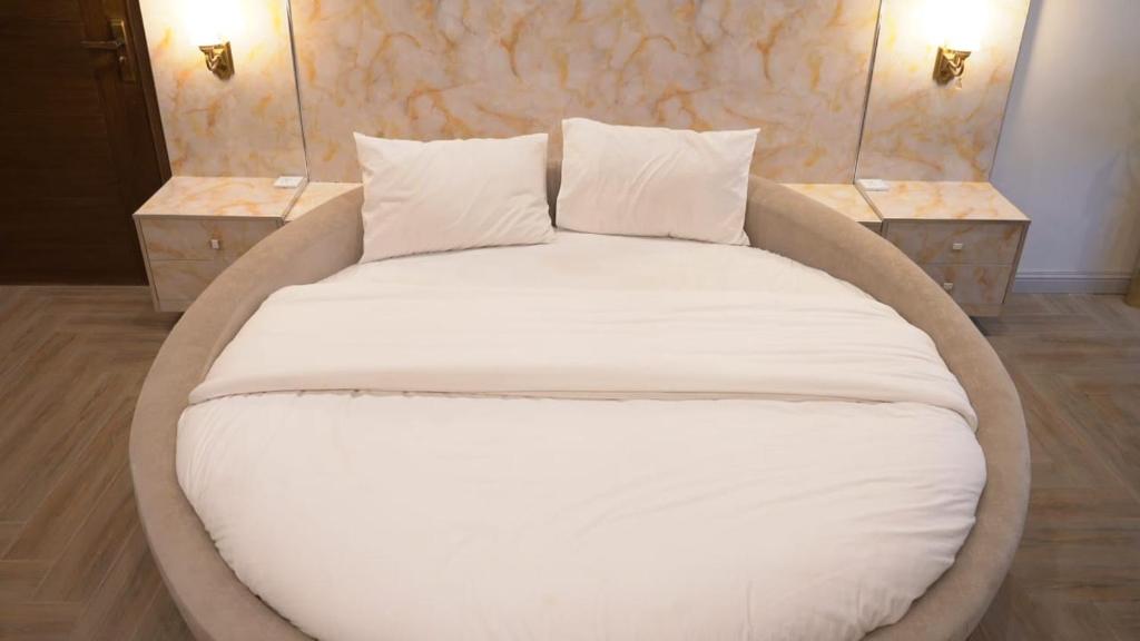 a large bed with white sheets and pillows in a room at Murree best apartment in Murree