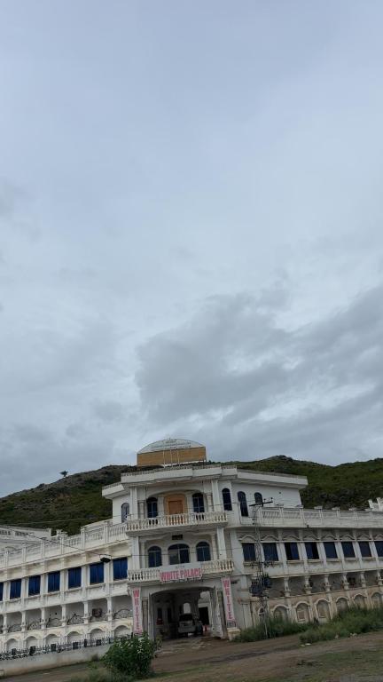 a large white building with a dome on top of it at White place hotel and resort in Khānpur