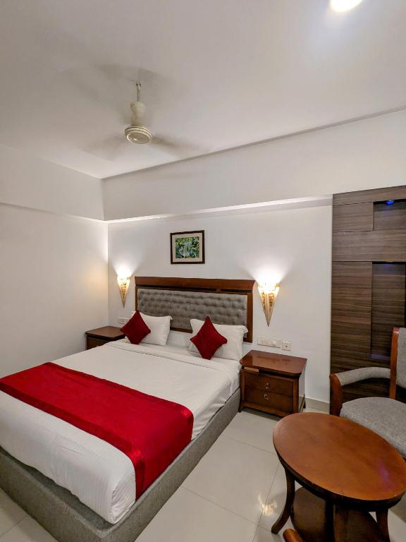 a bedroom with a large bed and a table at The Kunnathan Residency in Perumpāvūr