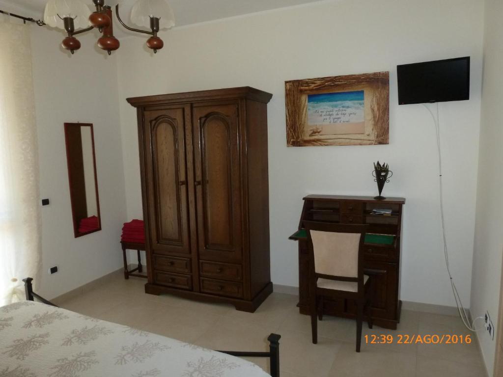 sypialnia z drewnianą szafką i biurkiem w obiekcie Sogno di mare w Puli