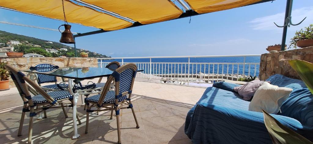 a patio with a table and chairs and the ocean at Relaxing Paradise Chez Nicolini in Erbalunga