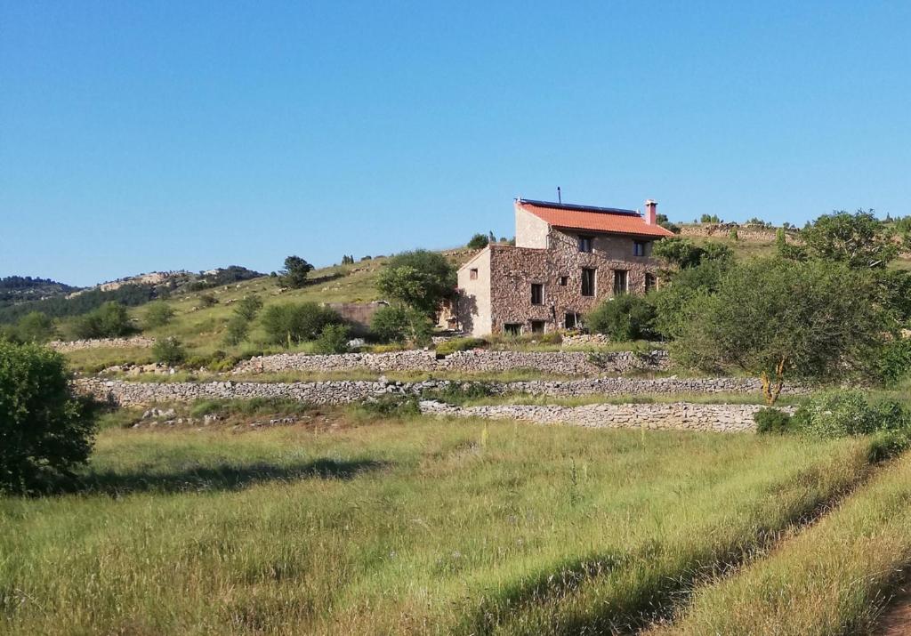 an old house on a hill in a field at Casa rural Más La Torreta con vistas al Pla de Vistabella cerca del Peñagolosa Pet Friendly niños gratis in Vistabella del Maestrazgo