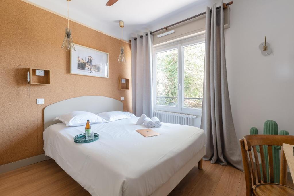 a bedroom with a white bed and a window at Hotel Bistrot FINE in Anglet