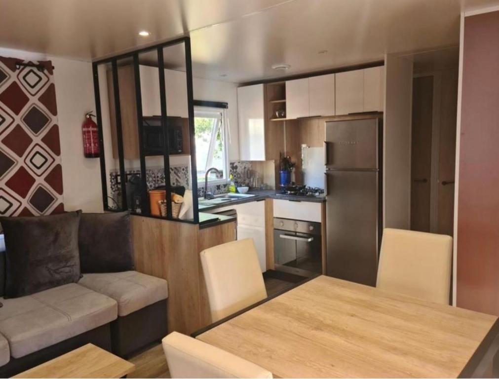 a kitchen with a couch and a table in a kitchen at Floriane in Claouey