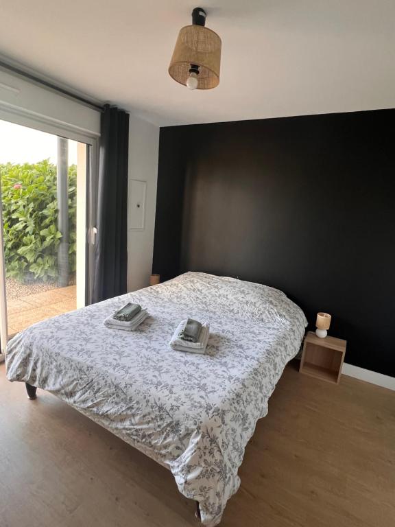 a bedroom with a bed with two towels on it at Chambre bordée par le GR34 in Sibiril