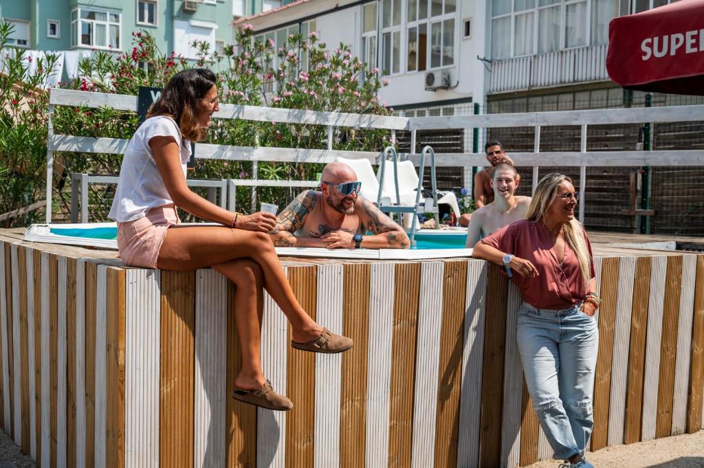 a group of people sitting on top of a fence at WOT Nomad Social in Lisbon