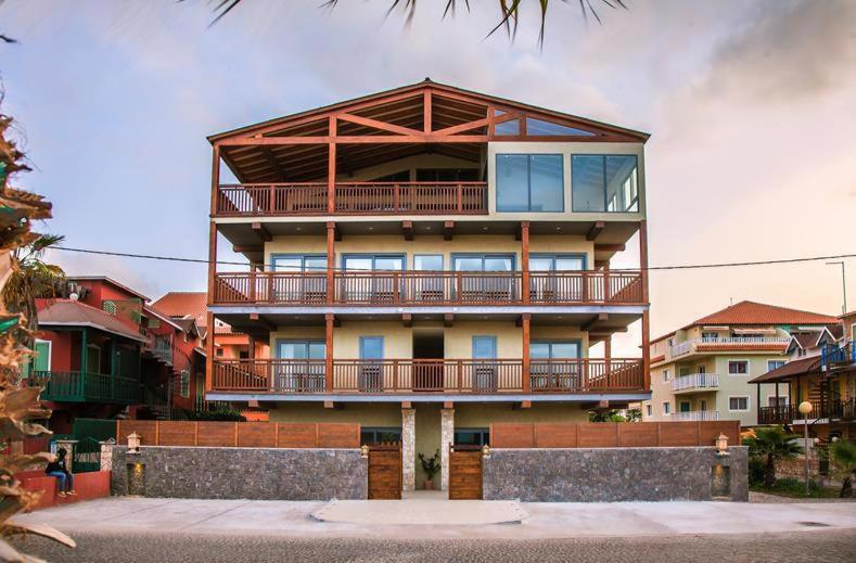 ein großes Gebäude mit einem Balkon auf dem Dach in der Unterkunft Buzio Beach Hotel in Santa Maria