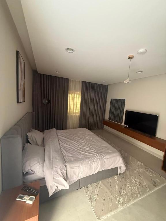 a bedroom with a bed and a flat screen tv at ليالينا in Dammam