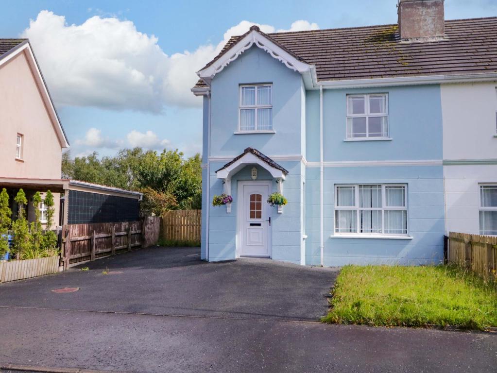 a blue house with a white door in a driveway at The Sperrin Getaway in Omagh