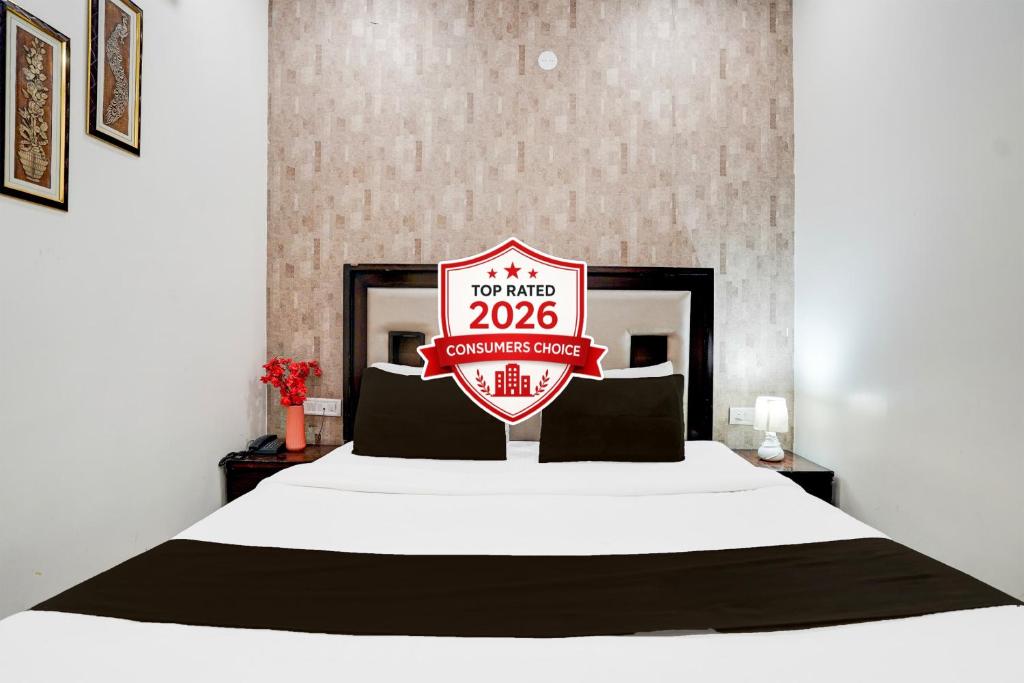 a hotel room with a bed with a sign on it at Super Hotel O Itwari Railway Station Formerly Hotel Prime in Nagpur