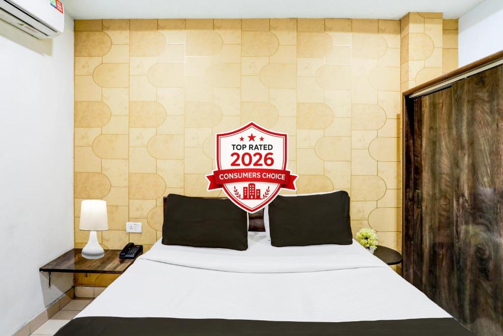 a bedroom with a bed with a sign on the wall at Super Collection O Hingna Road in Nagpur