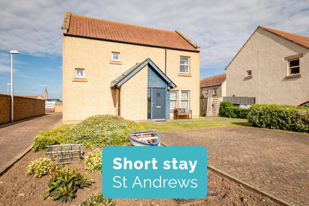 a brick house with a sign that says short stay st andrews at The View, 22 School Park in Kingsbarns