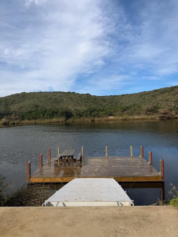 a dock on a lake with a table on it at LTB-Waterkant Cottage in Malgas