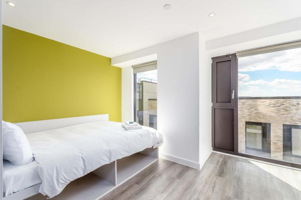 a bedroom with a bed and a green wall at Modern Studios in Central Coventry in Coventry
