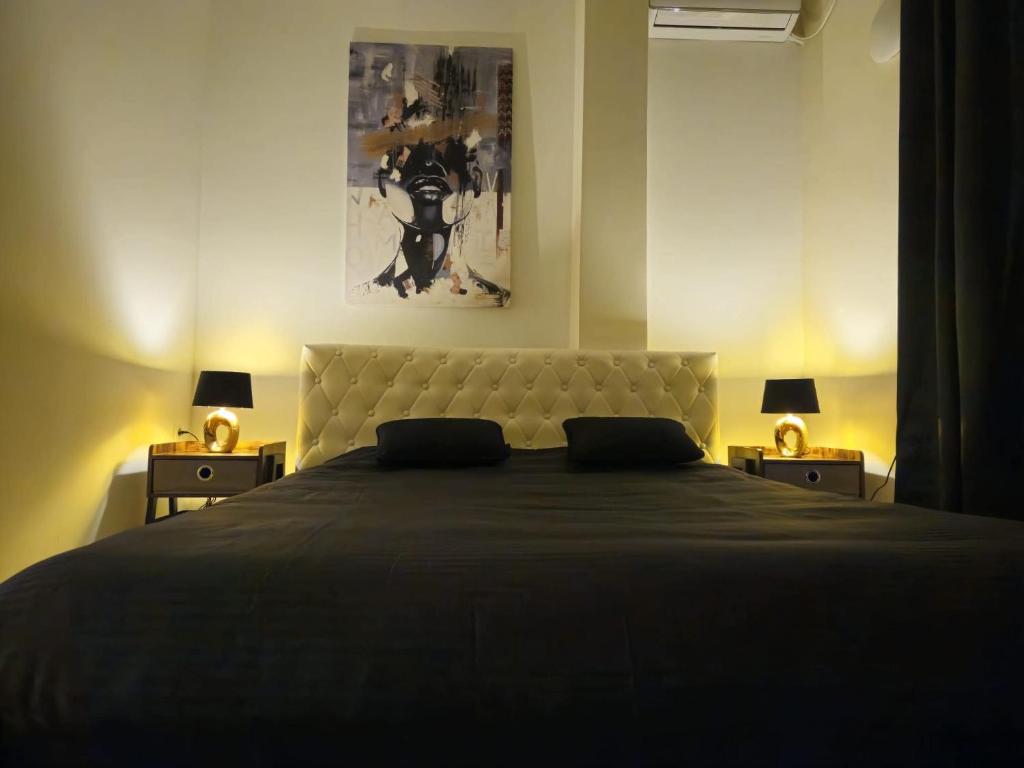 a bedroom with a large bed with two lamps at Merter Apartments in Kavadarci