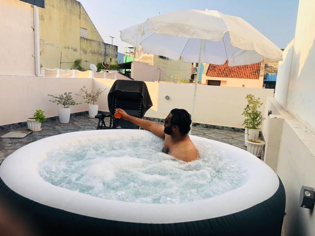 a man in a bath tub on a balcony at La Maison Du Bonheur in Pondicherry