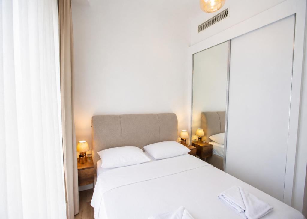 a bedroom with a white bed and a mirror at Abodos Aqualina D2/1 Fm in Vavilas