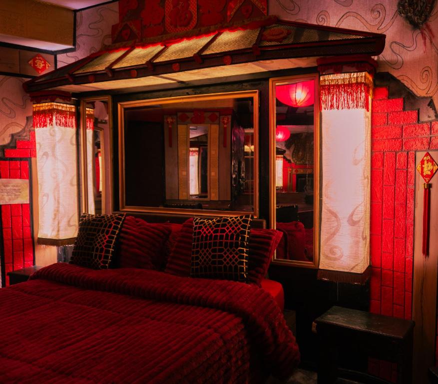 a bed in a room with a red comforter at Bellas Artes Palace Secret Suites Adult Only in Santiago
