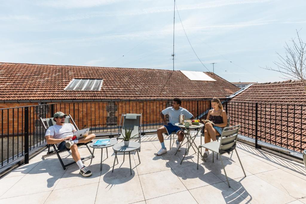 a group of three people sitting on a balcony at Outsite Bordeaux - Work, Connect, Explore in Bordeaux