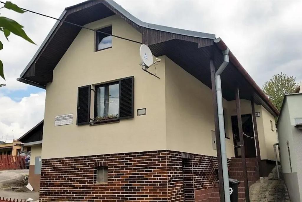 a house with a black roof and a window at Apartmán Marcel - Súľov in Súľov
