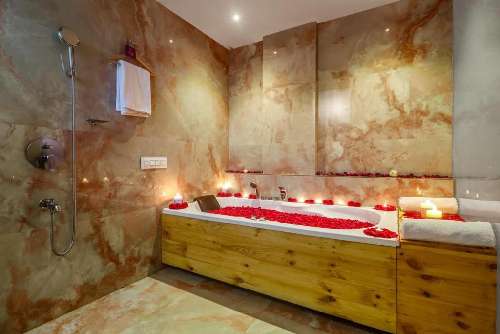 a bathroom with a tub with red roses in it at DSR Blue Suites in Hyderabad