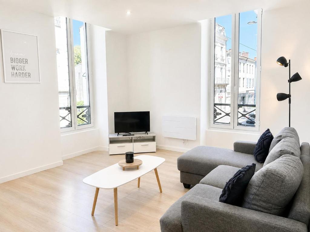 a living room with a couch and a tv at L'AUTHENTIQUE - Moderne - Central in Mont-de-Marsan