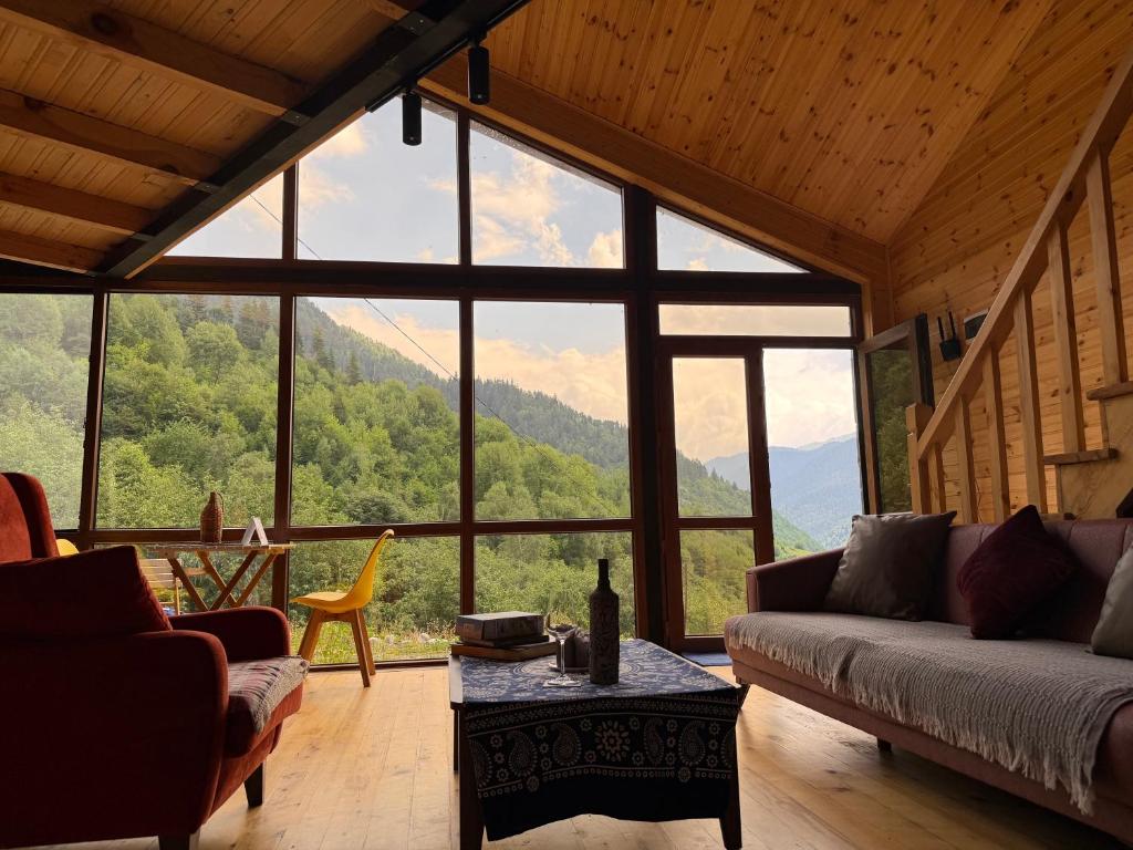 a living room with a couch and a large window at IparAlto in Mestia