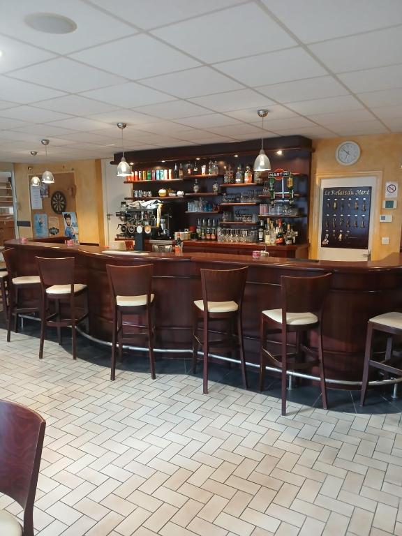 a bar with wooden stools in a restaurant at LE RELAIS DU mene in Le Gouray