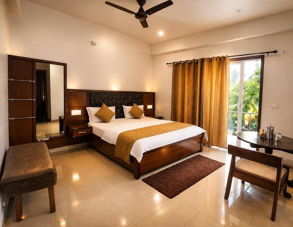 a bedroom with a bed and a table and a desk at Hotel bhawani palace Pipalkoti in Pīpalkoti