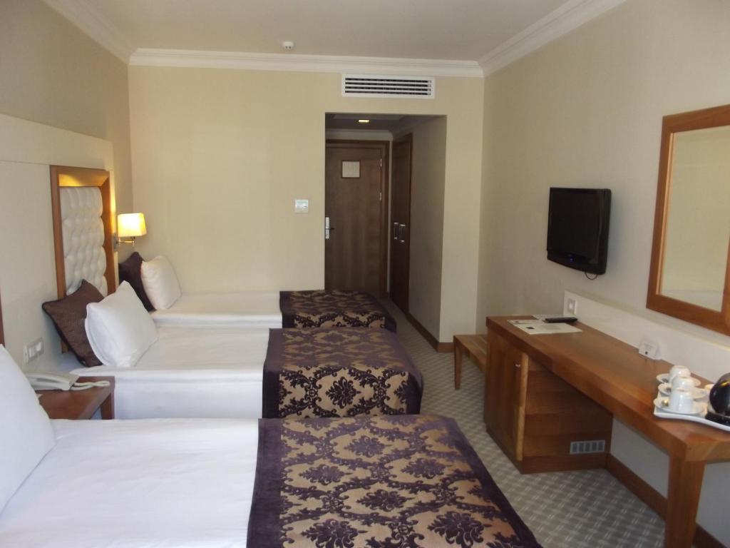 A television and/or entertainment centre at Tugcu Hotel Select