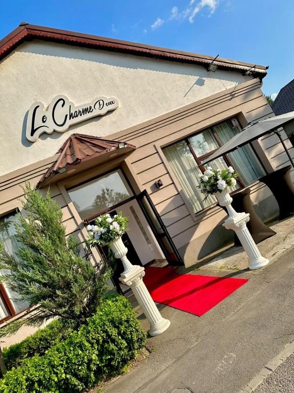 a building with two pillars with flowers in front of it at Le Charme Boutique in Bucharest