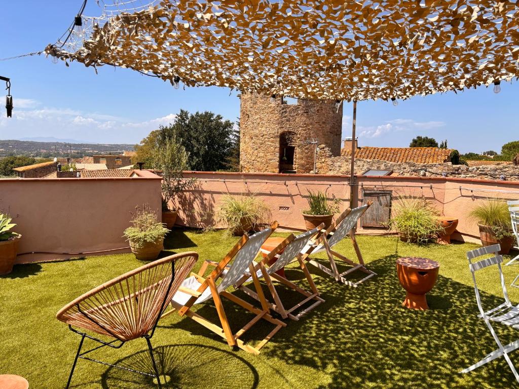 a group of chairs and an umbrella on a yard at El Fort d'Ullastret in Ullastret