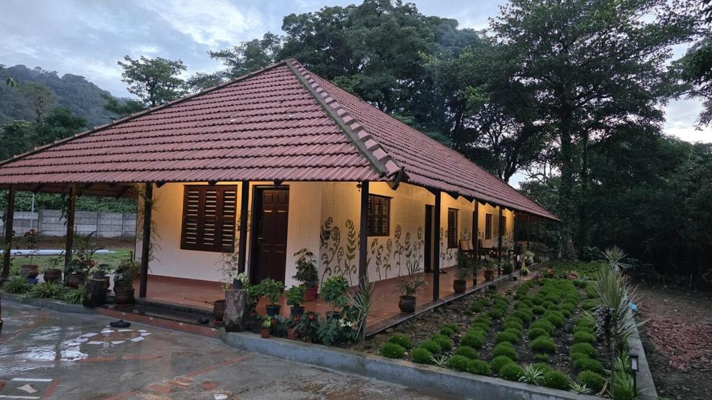 a small house with a lot of plants in front of it at Fiddlehead Fern in Kurchi