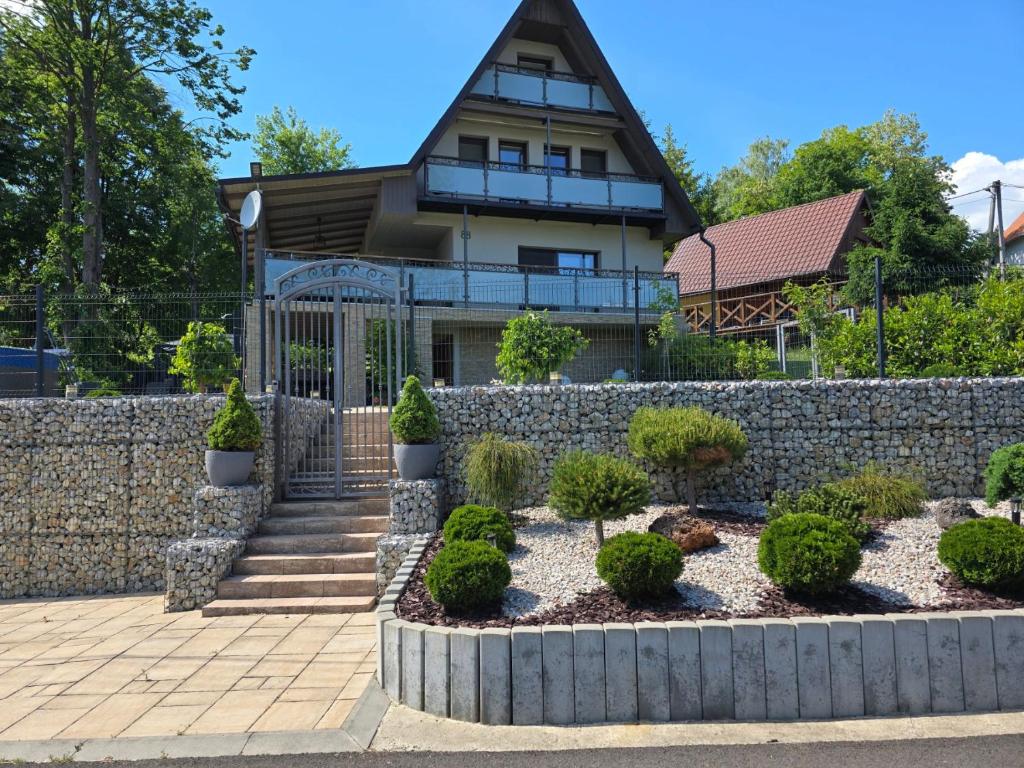 ein Haus mit einer Steinstützmauer und einem Garten in der Unterkunft Chata Domaša David in Bžany