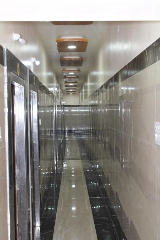 a long hallway with a row of mirrors on the wall at Srivari Lodge in Arcot