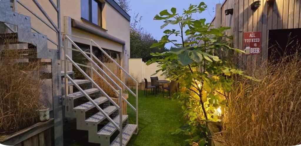 a garden with a spiral staircase next to a building at Starlette MelleRosePlace bij Cécile in Hoeksken
