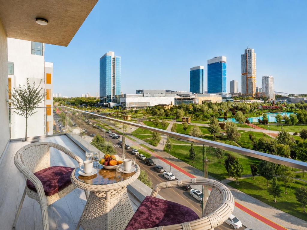 a balcony with a table and chairs and a city at 7 Star Apartments in Tashkent