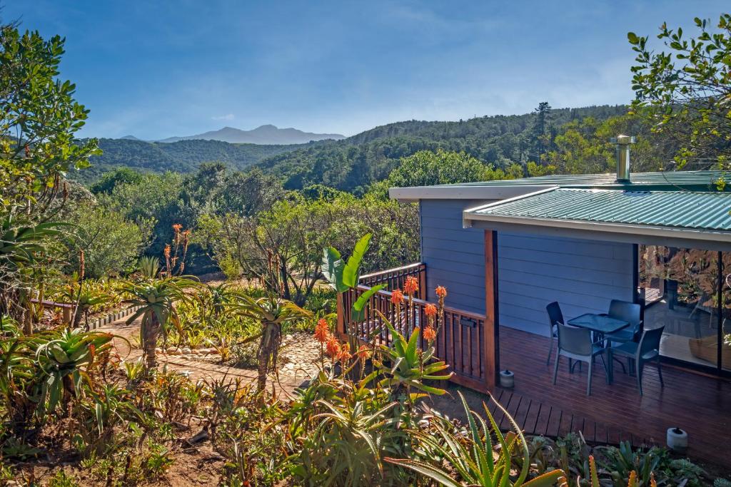a house with a deck with a table and chairs at Mountainview Sedgefield in Sedgefield