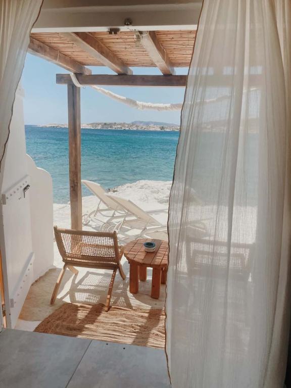a patio with a table and chairs and the ocean at Zacharias Seaside Studio Kimolos in Kimolos