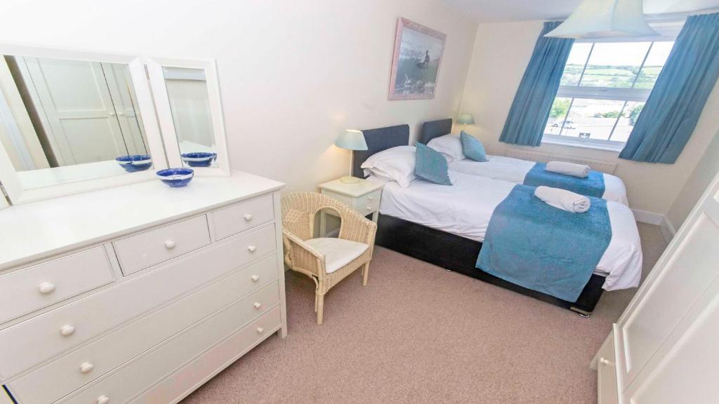 a bedroom with a bed with a dresser and a mirror at Cloudbreak Hot Tub Log Burner Dogs Welcome in Braunton