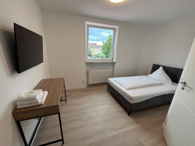a room with a bed and a table and a window at Hotel Ruble in Homburg