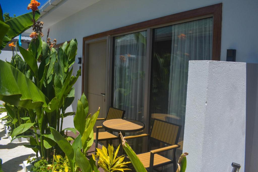 a patio with a table and chairs on a balcony at Tranquil Retreat Dhigurah in Dhigurah