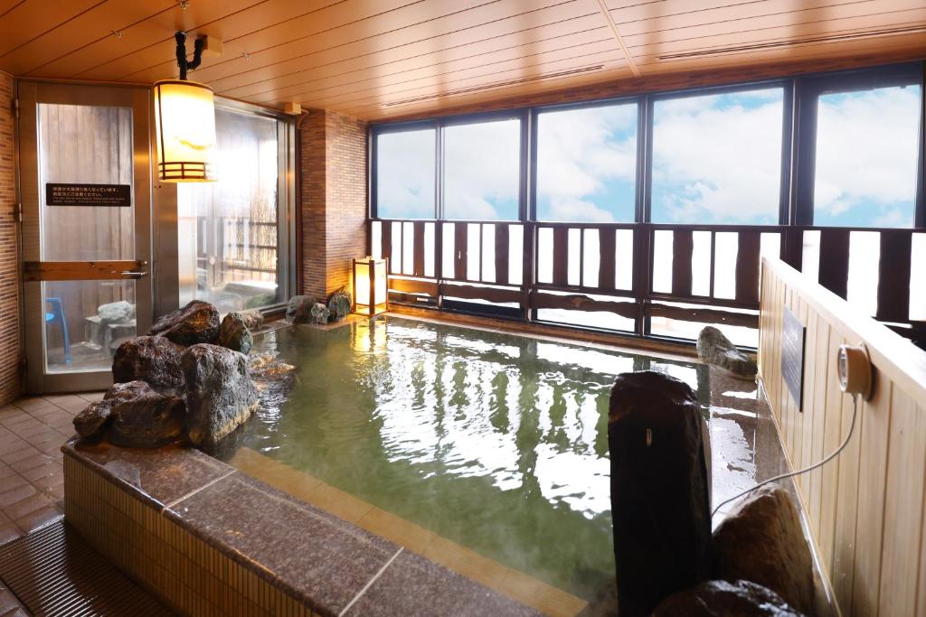 a large pool of water in a room with windows at Dormy Inn Express Kakegawa in Kakegawa