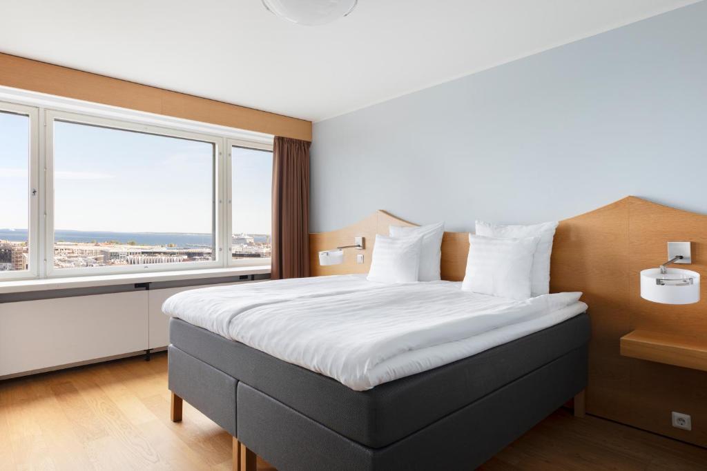a bedroom with a large bed with a large window at Original Sokos Hotel Viru in Tallinn