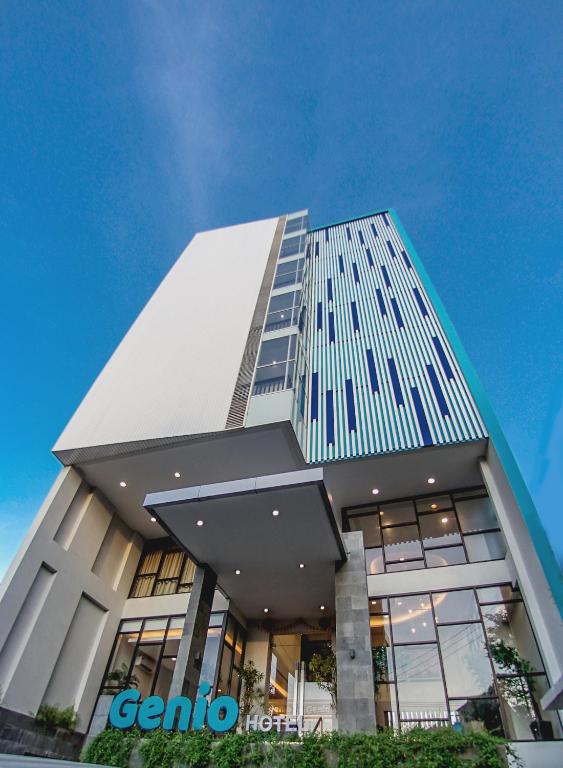 Un edificio alto con un cielo azul al fondo. en Genio Hotel Manado, en Manado