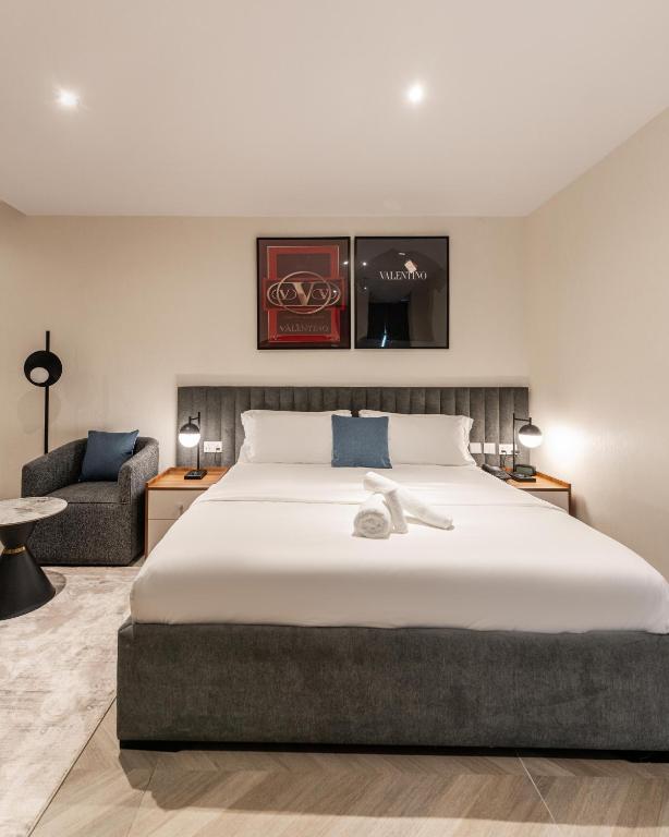 a bedroom with a large bed and a chair at Zee Residence in Lagos