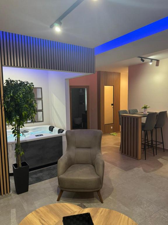 a living room with a chair and a bed at Omnia Lux Apartman 4C in Šabac