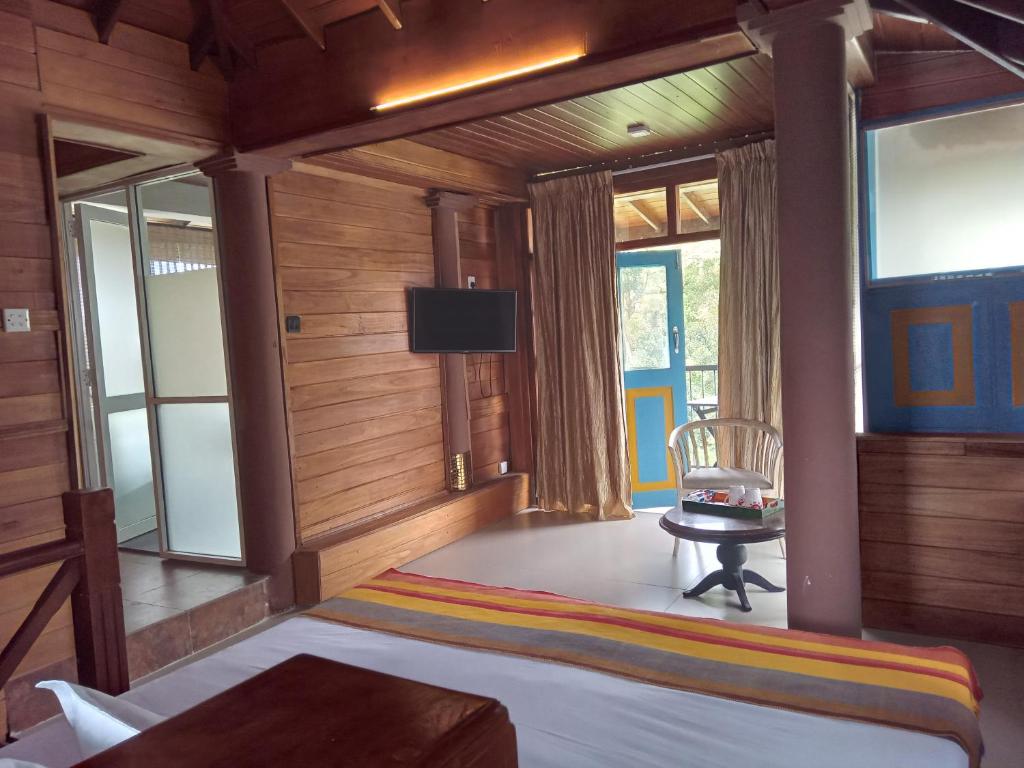 a bedroom with a bed and a tv and windows at Crown hills kandy in Kandy